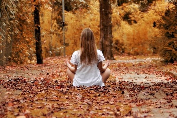 Una niña meditando en el bosque